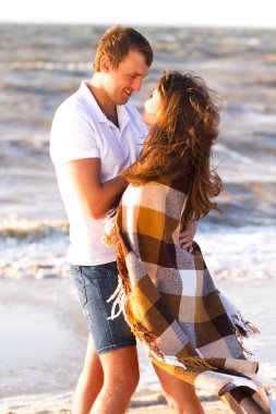 Mutlu genç aile rahatlatıcı gün batımında sahilde. Romantik kavramı seyahat aile