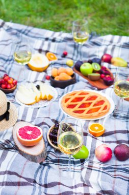Beyaz şarap ve yaz meyve yeşil çimenlerin üzerinde piknik arka plan