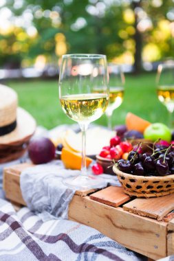 Beyaz şarap ve yaz meyve yeşil çimenlerin üzerinde piknik arka plan
