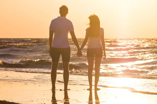 快乐的年轻家庭放松在海滩上日落 家庭旅行浪漫概念 — 图库照片