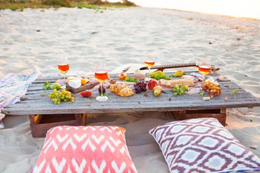 Boho tarzı gün batımında sahilde piknik. Romantik bir akşam yemeği, arkadaş parti, yaz aylarında, yiyecek ve içecek anlayışı