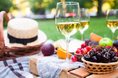 Beyaz şarap ve yaz meyve yeşil çimenlerin üzerinde piknik arka plan