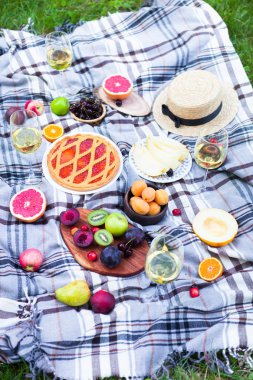 Beyaz şarap ve yaz meyve yeşil çimenlerin üzerinde piknik arka plan