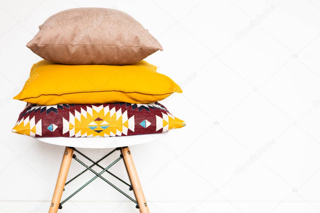 Cushions on the chair white wooden background with copy space. Sweet home and cozy concept. Close up