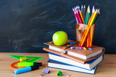 Geri okul cocept. Okul kitapları, kalemler ve elma yazı tahtası arka plan ile natürmort. Yakın çekim