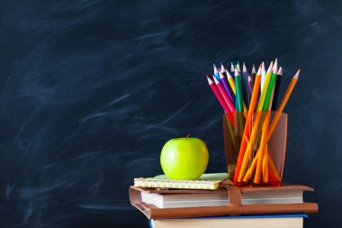 Geri okul cocept. Okul kitapları, kalemler ve elma yazı tahtası arka plan ile natürmort. Yakın çekim