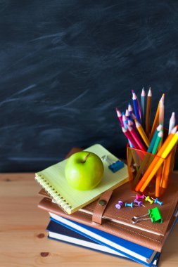 Geri okul cocept. Okul kitapları, kalemler ve elma yazı tahtası arka plan ile natürmort. Yakın çekim
