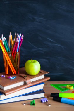 Geri okul cocept. Okul kitapları, kalemler ve elma yazı tahtası arka plan ile natürmort. Yakın çekim