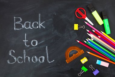 Okul için kavram. Okul blackboard arka planda, dershanede - kalem, defter, makas, tebeşir, işaretçileri için aksesuar malzemeleri. Alan üst görünüm Kopyala