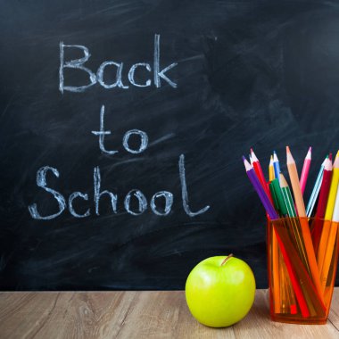 Natürmort okul kitapları, kalemler ve elma yazı tahtası 