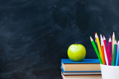 Geri okul cocept. Okul kitapları, kalemler ve elma yazı tahtası arka plan ile natürmort. Yakın çekim