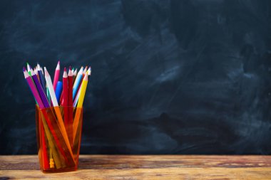 Geri okul kavramı için! Kopya alanı ile okul kara tahta arka plan üzerine bir bardak renkli kalemler