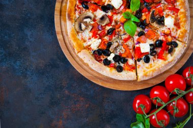 Ev yapımı sıcak pizza domates, mozzarella ve fesleğen ile. Karanlık taş tablo kopya alanı ile üstten görünüm.