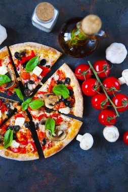 Ev yapımı sıcak pizza domates, mozzarella ve fesleğen ile. Karanlık taş tablo kopya alanı ile üstten görünüm.