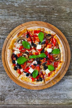 Ev yapımı sıcak pizza domates, mozzarella ve fesleğen ile. Ahşap masa üzerinde kopya alanı ile üstten görünüm.