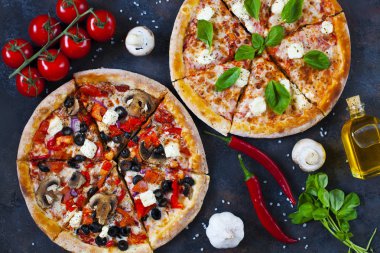 Ev yapımı sıcak pizza domates, mozzarella ve fesleğen ile. Karanlık taş tablo kopya alanı ile üstten görünüm.