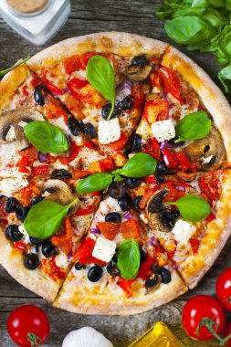 Ev yapımı sıcak pizza domates, mozzarella ve fesleğen ile. Ahşap masa üzerinde kopya alanı ile üstten görünüm.