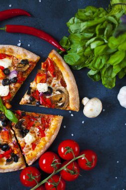 Ev yapımı sıcak pizza domates, mozzarella ve fesleğen ile. Karanlık taş tablo kopya alanı ile üstten görünüm.