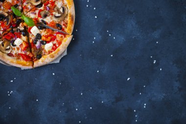 Ev yapımı sıcak pizza domates, mozzarella ve fesleğen ile. Karanlık taş tablo kopya alanı ile üstten görünüm.