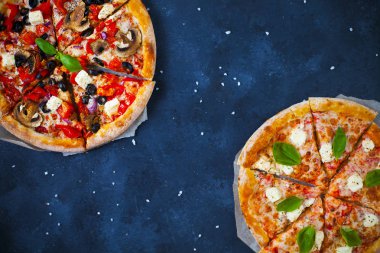 Ev yapımı sıcak pizza domates, mozzarella ve fesleğen ile. Karanlık taş tablo kopya alanı ile üstten görünüm.
