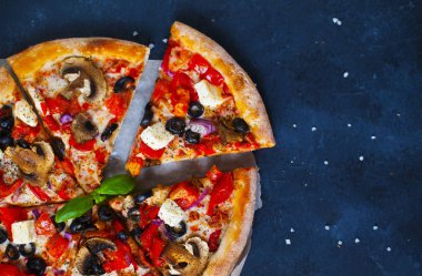 Ev yapımı sıcak pizza domates, mozzarella ve fesleğen ile. Karanlık taş tablo kopya alanı ile üstten görünüm.