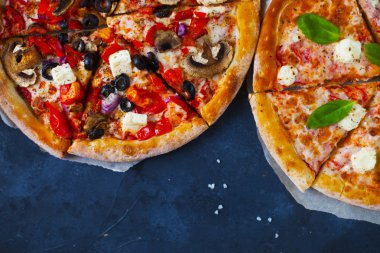 Ev yapımı sıcak pizza domates, mozzarella ve fesleğen ile. Karanlık taş tablo kopya alanı ile üstten görünüm.