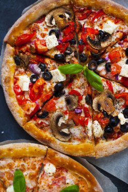 Ev yapımı sıcak pizza domates, mozzarella ve fesleğen ile. Karanlık taş tablo kopya alanı ile üstten görünüm.