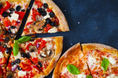 Ev yapımı sıcak pizza domates, mozzarella ve fesleğen ile. Karanlık taş tablo kopya alanı ile üstten görünüm.