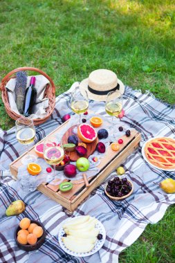 Beyaz şarap ve yaz meyve yeşil çimenlerin üzerinde piknik arka plan