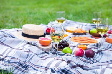 Beyaz şarap ve yaz meyve yeşil çimenlerin üzerinde piknik arka plan
