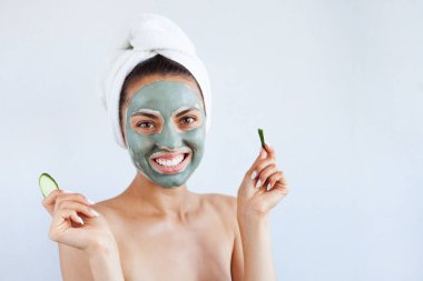 Terapötik mavi çamur maskeli genç ve güzel bir kadın. Spa tedavisi, kişisel bakım ve sağlıklı cilt. Boşluğu kopyala, beyaz arkaplan