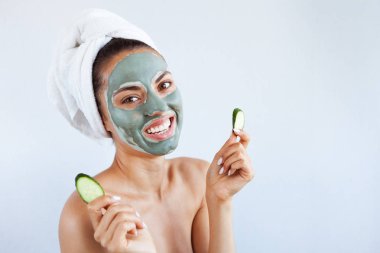 Terapötik mavi çamur maskeli genç ve güzel bir kadın. Spa tedavisi, kişisel bakım ve sağlıklı cilt. Boşluğu kopyala, beyaz arkaplan