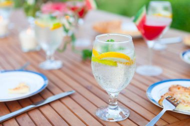 Aile açık yemek bahçede yaz gün batımında. Piknik yiyecek ve içecek konsepti