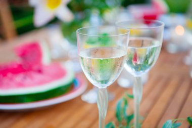 İki bardak beyaz şarap. Aile açık yemek bahçede yaz gün batımında. Piknik yiyecek ve içecek konsepti