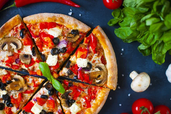 Ev yapımı sıcak pizza domates, mozzarella ve fesleğen ile. Karanlık taş tablo kopya alanı ile üstten görünüm.