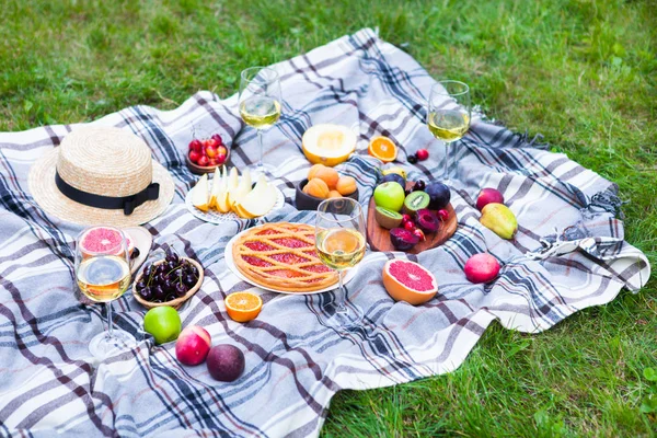 Beyaz şarap ve yaz meyve yeşil çimenlerin üzerinde piknik arka plan
