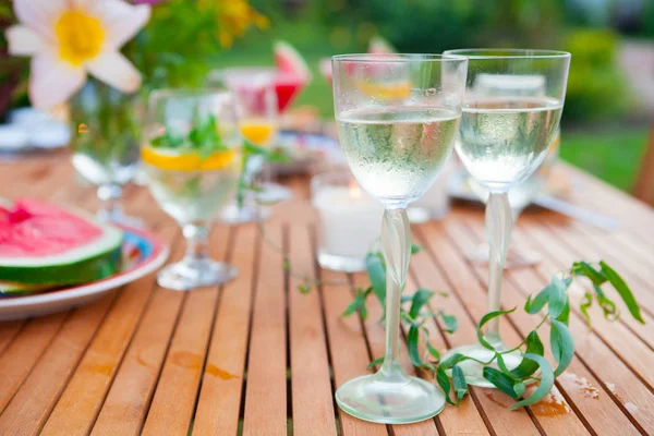 Two glasses of white wine. Family outdoor dinner in the garden in summertime at sunset. Picnic food and drink concept