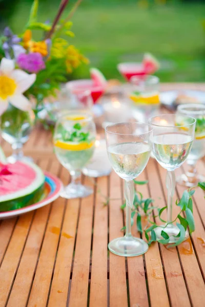 İki bardak beyaz şarap. Aile açık yemek bahçede yaz gün batımında. Piknik yiyecek ve içecek konsepti