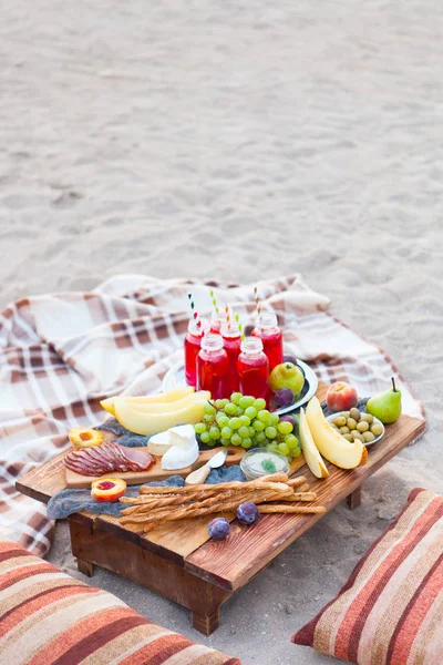 Piknik na plaży o zachodzie słońca w stylu boho. Koncepcja bas — Zdjęcie stockowe