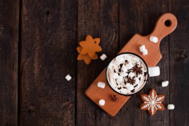 Bir fincan sıcak çikolata veya kakao ile Noel kurabiyeleri ve koyu ahşap arka plan üzerinde marsmallow