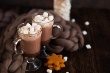 İki bardak kakao, kahve Lokum ve merinose yün üzerinden rahat kareli koyu ahşap zemin üzerine ev yapımı kurabiye ile. Kış, yeni yıl, yılbaşı natürmort.