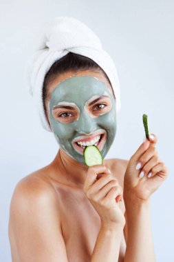 Terapötik mavi çamur maskeli genç ve güzel bir kadın. Spa tedavisi, kişisel bakım ve sağlıklı cilt. Boşluğu kopyala, beyaz arkaplan