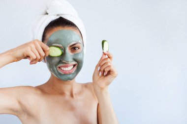 Terapötik mavi çamur maskeli genç ve güzel bir kadın. Spa tedavisi, kişisel bakım ve sağlıklı cilt. Boşluğu kopyala, beyaz arkaplan