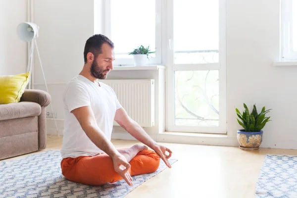 Hombre practicando yoga y meditación en casa. Una serie de yoga pos — Foto de Stock