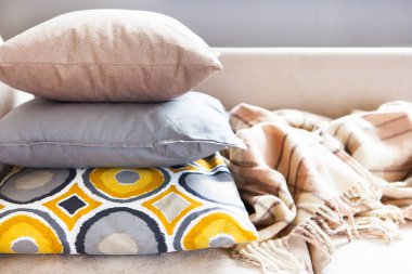 Bej kanepeüzerinde yastıklar ve ekose kopyalama alanı ile yakın. S