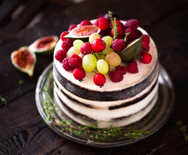 Rustik bir backg üzerinde incir ve çilek ile Lezzetli çikolatalı kek