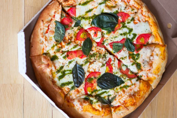 Pizza italiana sabrosa caliente con verduras en caja en backgro de madera —  Fotos de Stock
