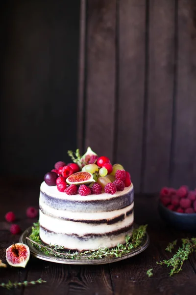 Delicioso pastel de chocolate con higos y bayas en un respaldo rústico Imagen de archivo