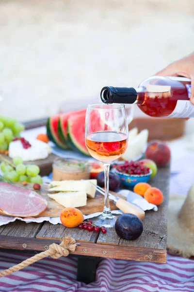 Picnic on the beach at sunset in the style of boho, food and dri — Stock Photo, Image