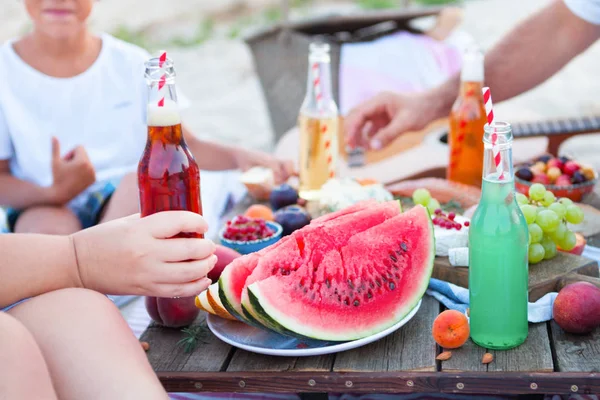 Пікнік на пляжі на заході сонця в стилі бохо, їжа та напої Ліцензійні Стокові Фото